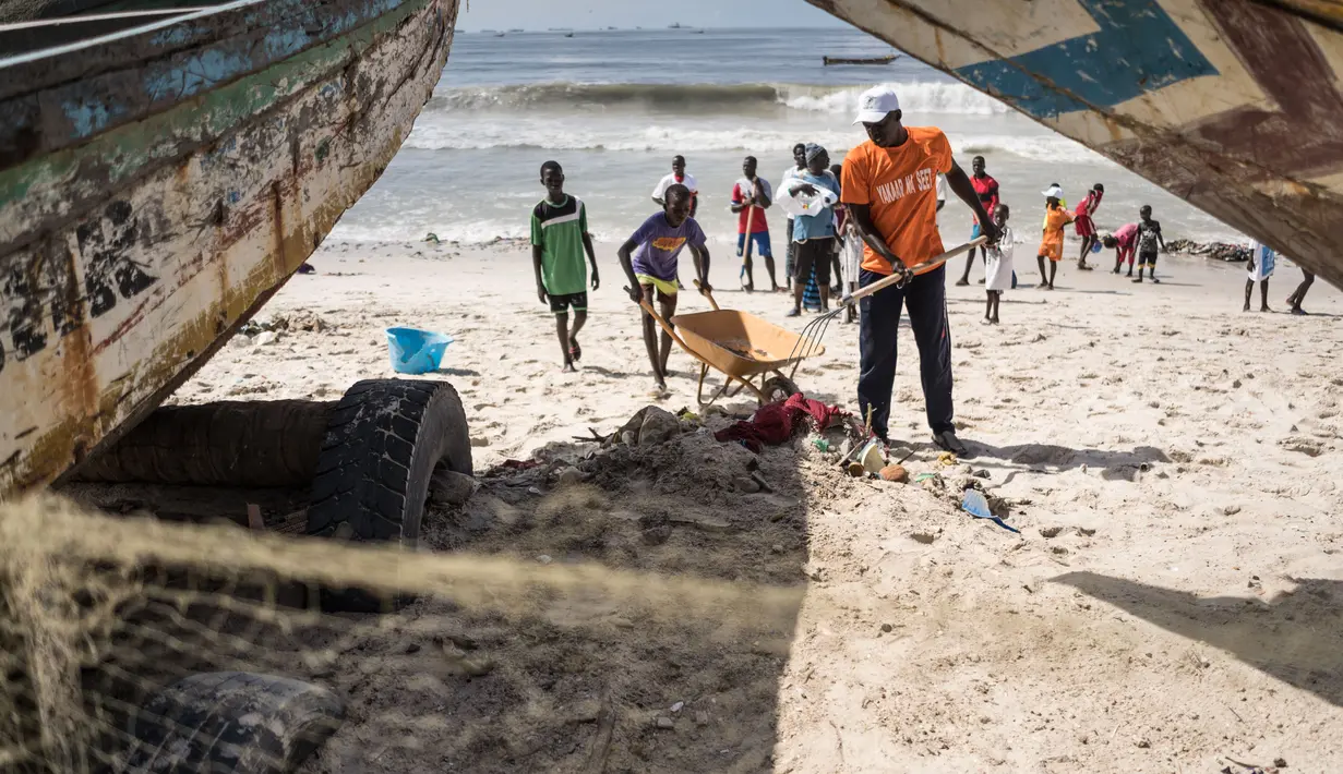 Anak-anak di lingkungan sekitar bergabung dengan relawan untuk membersihkan pantai di pinggiran Dakar, Senegal (13/9/2020). Karena sampah yang terbawa gelombang laut dan curah hujan selama musim hujan telah mencemari pantai. (Xinhua/Louis Denga)