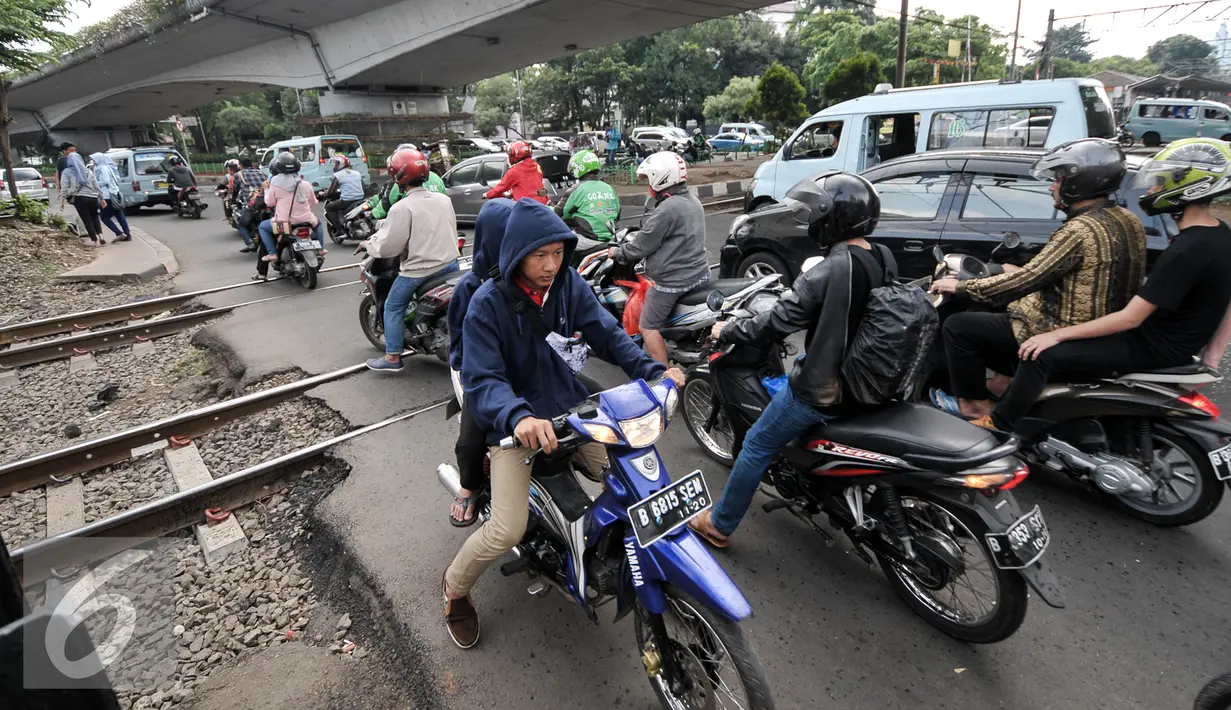 Sejumlah kendaraan melintasi perlintasan sebidang di Stasiun Duren Kalibata, Jakarta, Kamis (14/7). Sudin Perhubungan dan Transportasi berencana akan menutup permanen perlintasan sebidang di Stasiun KA Duren Kalibata. (Liputan6.com/Yoppy Renato)