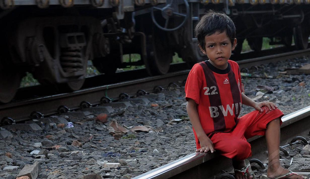 Seorang bocah laki-laki tampak duduk di bantalan rel kawasan Jakarta Barat, Jumat (20/06/14). (Liputan6.com/Faisal R Syam)