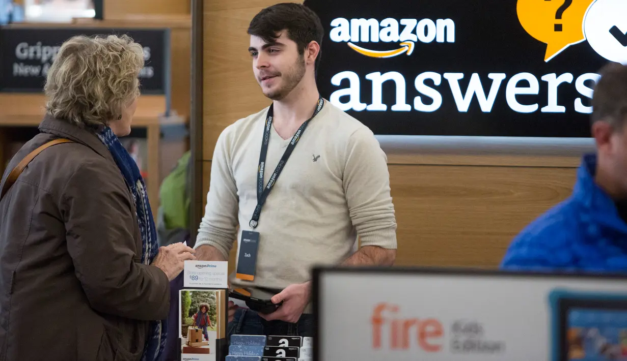 Seorang karyawan membantu pelanggan di toko Amazon Books di University Village, Seattle, Washington, Selasa (3/11). Setelah 20 tahun mejual buku secara online, akhirnya Amazon membuka toko buku fisik pertamanya. (AFP Photo/Jason Redmond)