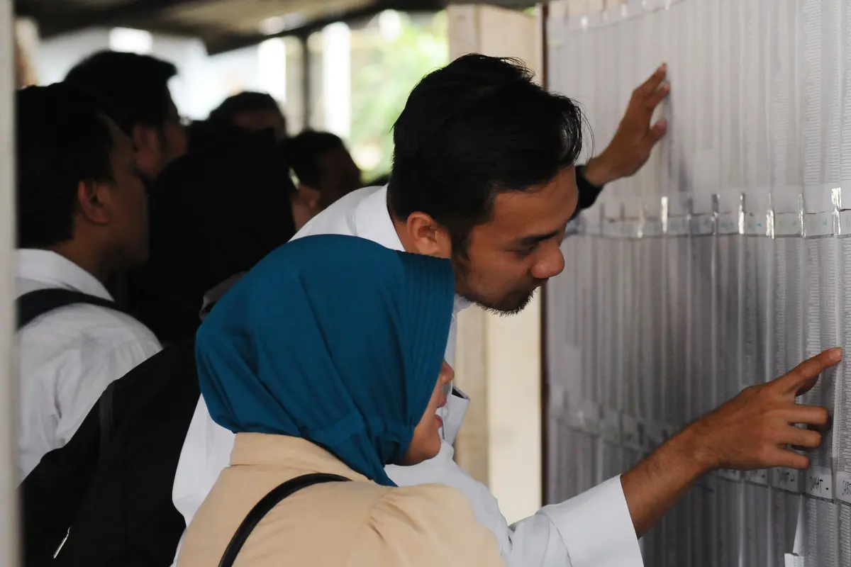 Peserta tes seleksi CPNS Kemenkumham mengecek no pendaftaran di gedung BKN, Jakarta, Senin (11/9). Pada 2017, tercatat 1.116.138 pelamar CPNS mendaftar di lingkungan Kemenkumham. (Liputan6.com/Helmi Fithriansyah)