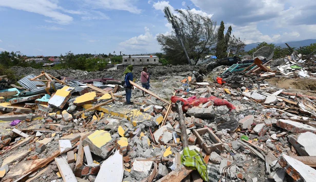Warga memeriksa puing-puing di mana rumah mereka berdiri sebelum gempa dan tsunami di Petobo, Palu, Kamis (4/10). Wilayah Kelurahan Petobo di Palu menjadi salah satu daerah yang terkena dampak parah karena 'ditelan bumi'. (AFP/ ADEK BERRY)
