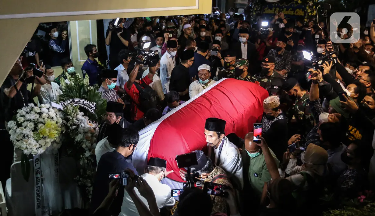 Saudara serta Kerabat mengangkat dan mendorong Peti Jenazah Ketua Dewan Pers Azyumardi Azra di rumah duka di Perumahan Puri Laras II, Cirendeu, Tangerang Selatan, Selasa (20/9/2022) dinihari. Azyumardi Azra meninggal dunia pada Minggu (18/9/2022) di rumah sakit Kedah, Selangor, Malaysia pukul 12.30 waktu setempat, dan rencana akan dimakamkan Selasa (20/9/2022) di Taman Makam Pahlawan (TMP) Kalibata. (Liputan6.com/Johan Tallo)