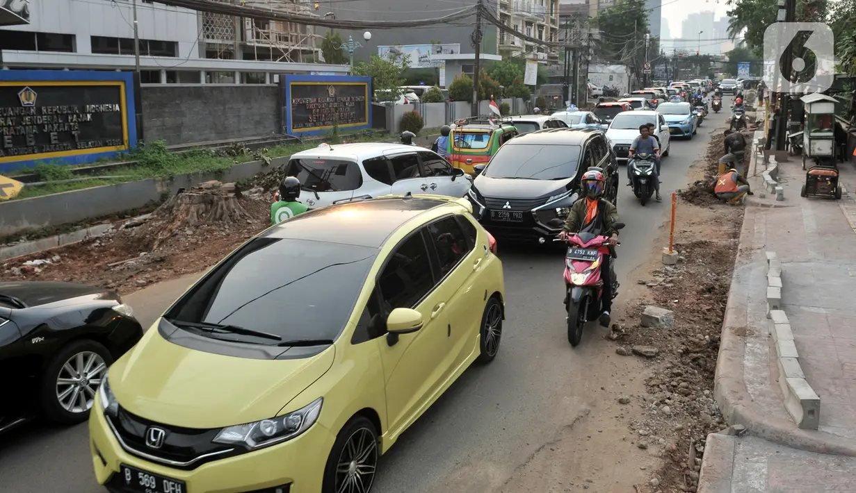 Laju kendaraan tersendat saat melintasi proyek revitalisasi trotoar di Jalan Tebet Raya, Jakarta, Selasa (5/11/2019). Adanya proyek revitalisasi trotoar di sepanjang Jalan Tebet Raya mengakibatkan kemacetan di kawasan tersebut semakin parah, terlebih saat jam sibuk. (merdeka.com/Iqbal Nugroho)