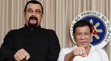 Presiden Filipina, Rodrigo Duterte (kanan) menunjukkan pukulan tinju bersama aktor laga Hollywood, Steven Seagal yang sedang melakukan kunjungan kehormatan di Istana Kepresidenan Malacanang di Manila, Kamis (12/10). (Handout/PPD/AFP)