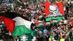 Para suporter Celtic mengibarkan bendera Palestina saat melawan Hapoel Beer Sheva asal Israel di pertandingan babak kualifikasi play off Liga Champions di Celtic park, (19/8).  Celtic menang atas Hapoel dengan skor 5-2. (REUTERS/Russell Cheyne)