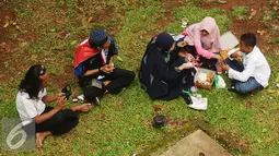 Massa aksi damai berkumpul makan di pinggirJalan Merdeka Barat, Jakarta, Jumat (4/11). Massa melakukan aksi di depan Istana Negara menuntut penegakan hukum kasus dugaan penistaan agama. (Liputan6.com/Helmi Fithriansyah)
