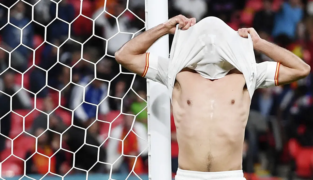 Pemain Timnas Spanyol, Mikel Oyarzabal, menutup wajahnya dengan jersey usai ditaklukkan Italia pada laga semifinal Euro 2020. (Foto:AP/Andy Rain,Pool)
