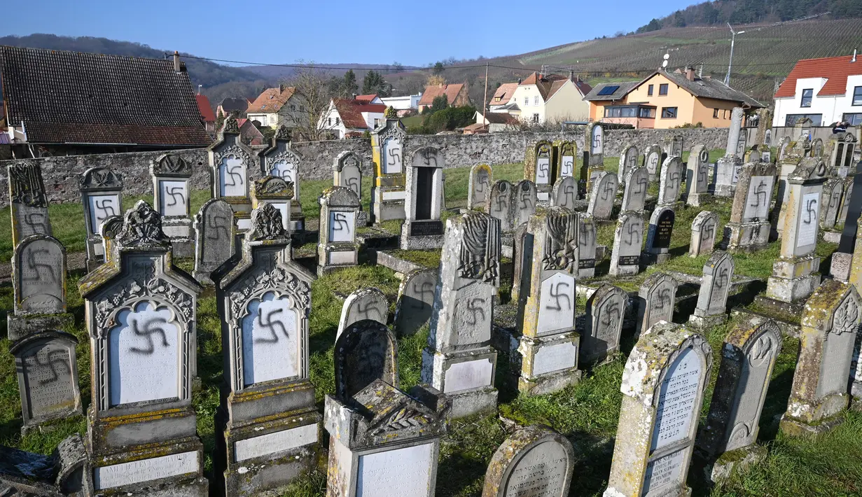 Suasana makam yang dicoreti lambang swastika Nazi di pemakaman Yahudi, Westhoffen, dekat Strasbourg, Prancis, Rabu (4/12). Sedikitnya 107 makam menjadi sasaran vandalisme dengan dicoreti lambang swastika Nazi. (AFP/Patrick Hertzog)