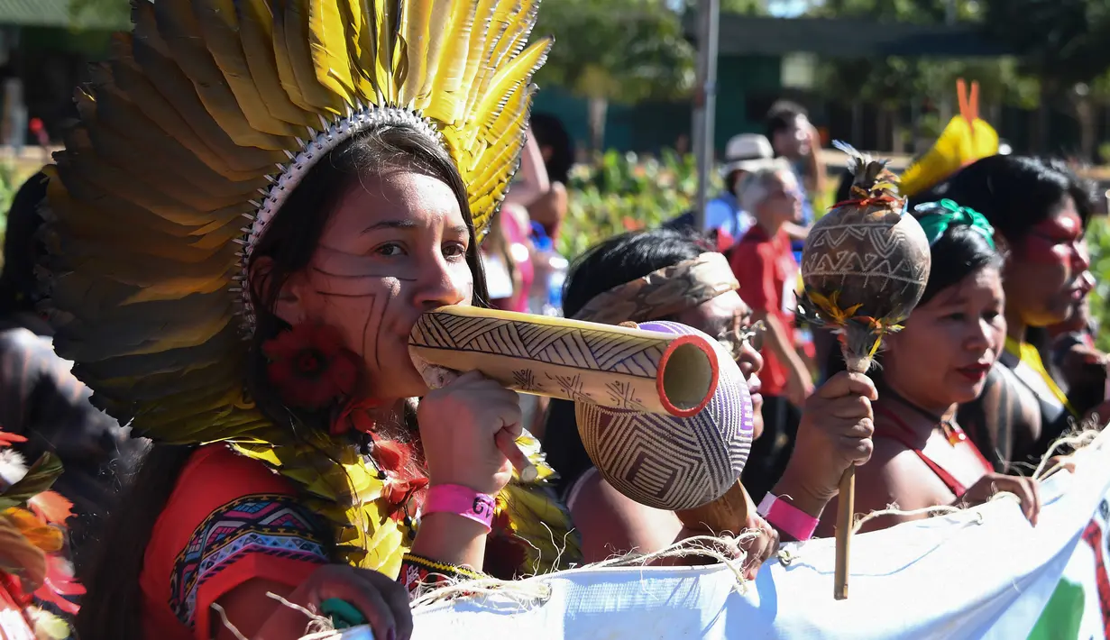 Perempuan pribumi saat mengikuti protes terkait kebijakan Presiden Brasil Jair Bolsonaro di Brasilia, Selasa (13/8/2019). Demonstrasi diikuti sekitar 3.000 perempuan pribumi dari seluruh Brasil. (EVARISTO SA/AFP)
