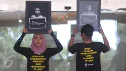 Sejumlah aktivis memegang poster saat menggelar aksi protes di depan Kemenaker, Jakarta, Jumat (9/12). Mereka mendesak Pemerintah untuk memperbaiki kebijakan penempatan buruh migran anak buah kapal asing di luar negeri. (Liputan6.com/Helmi Afandi)