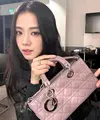 Jisoo BLACKPINK tampil kasual dengan atasan hitam dengan tas Dior Small Lady D-Joy berwarna peony pink. [Dior].