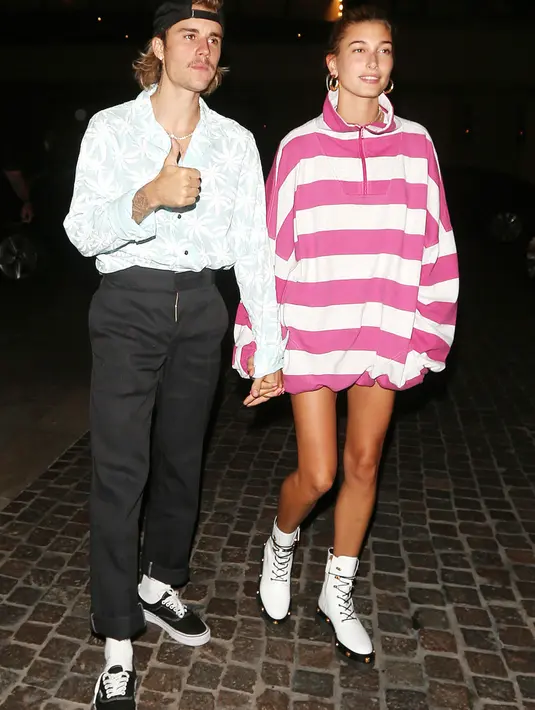 Nah kalau ini Justin Bieber mulai bergaya 80-an. Sementara Hailey menggunakan oversized sweatshirt berwarna pink garis-garis putih. (Mega/USWeekly)