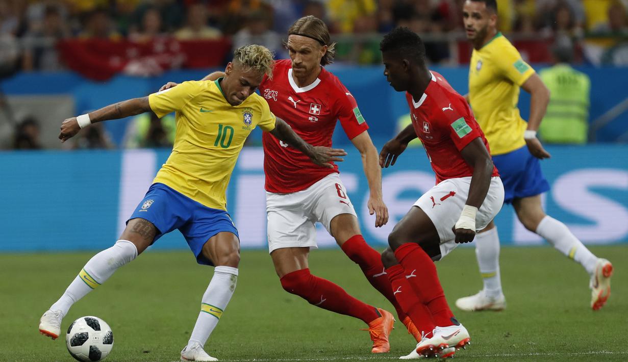 Striker Brasil, Neymar, berusaha melewati kepungan pemain Swiss pada laga Grup E Piala Dunia di Rostov Arena, Rostov-on-Don, Minggu (17/6/2018). Kedua negara bermain imbang 1-1. (AP/Darko Vojinovic)