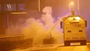 Sebuah mobil meriam air menyemprotkan air untuk memadamkan api sisa ledakan bom di dekat stadion sepak bola di Istanbul, Turki, Sabtu (10/12). Ledakan itu menyebabkan 29 orang tewas, dan melukai 166 orang lainnya. (Reuters/Murad Sezer)