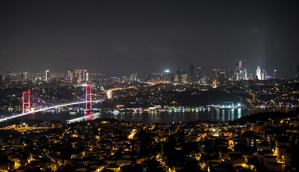 Pemandangan malam Jembatan Martir 15 Juli atau yang lebih dikenal dengan Jembatan Bosphorus di Istanbul, Turki, Jumat (24/8). Jembatan Bosphorus merentang di atas Selat Bosporus. (OZAN KOSE/AFP)