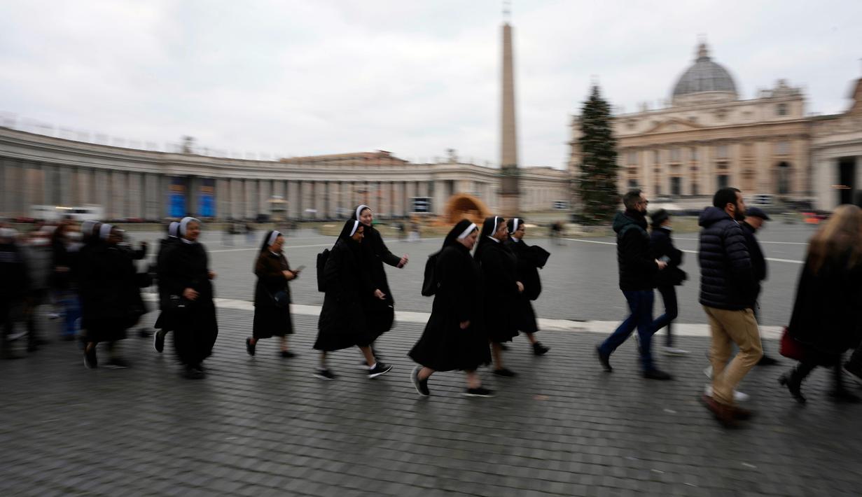 Orang-orang mengantre untuk memasuki Basilika Santo Petrus tempat mendiang Paus Emeritus Benediktus XVI disemayamkan di Vatikan, Senin (2/1/2023). Benediktus XVI, teolog Jerman yang akan dikenang sebagai paus pertama dalam 600 tahun yang mengundurkan diri, telah meninggal pada 31 Desember 2022 di usia 95 tahun. (AP Photo/Alessandra Tarantino)