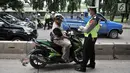 Polisi memberhentikan sepeda motor yang melintasi jalur bus Transjakarta di Jalan Yos Sudarso, Jakarta, Senin (21/1). Razia rutin ini digelar untuk menjaring pengendara yang nekat menerobos jalur bus Transjakarta. (Merdeka.com/Iqbl Nugroho)