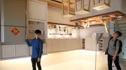 Pengunjung berpose di ruangan dapur rumah terbalik di Huashan Creative Park, Taipei, Taiwan, (7/4). Sekelompok arsitek Taiwan membangun rumah seluas 300 meter yang menghabiskan dana US$ 600.000 dalam kurun waktu 2 bulan. (REUTERS/Tyrone Siu)