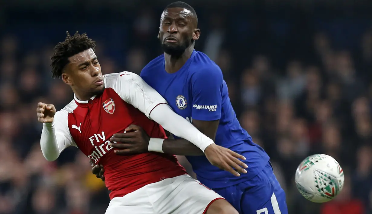 Duel pemain Arsenal, Alex Iwobi (kiri) dan pemain Chelsea, Antonio Rudiger ada laga leg pertama semifinal Piala Liga Inggris di Stamford Bridge, London, (10/01/2018). Chelsea bermain imbang 0-0 lawan Arsenal. (AFP/Ian Kington)