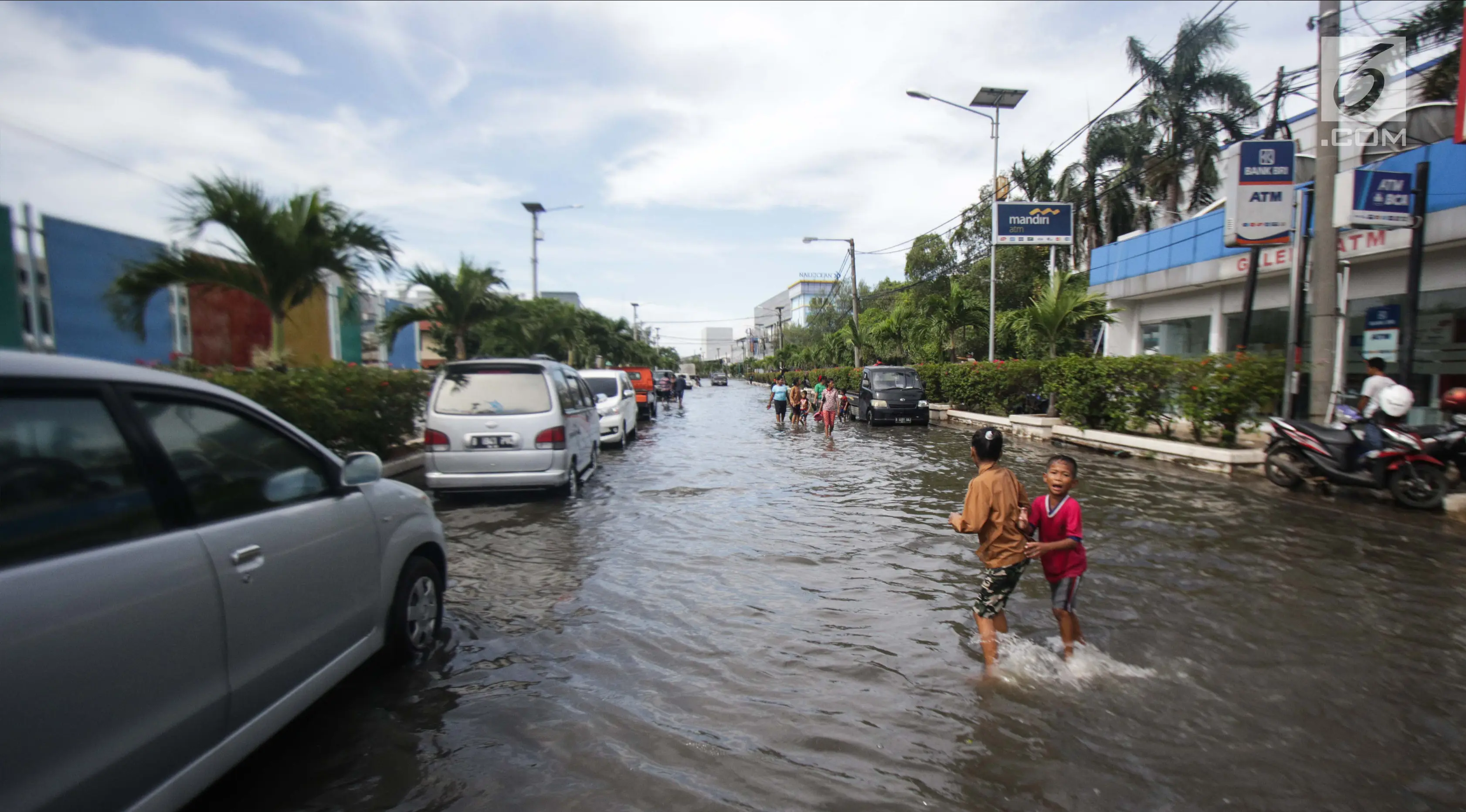 Sejumlah anak-anak bermain di genangan banjir rob di kawasan Muara Baru, Jakarta, Rabu (6/11). (Liputan6.com/Faizal Fanani)