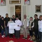 Komisaris Utama Askrindo Syariah, Siti Ma’rifah (keenam kiri) disaksikan  Direktur Pemasaran Askrindo Syariah, Aviantono Yudihariadi, Direktur Kepatuhan, SDM, dan MR Askrindo, Kun Wahyu Wardana dan karyawan Askrindo Group secara simbolis menyerahkan bantuan kepada Bupati Cianjur, Herman Suherman (kelima kanan) untuk warga terdampak gempa Cianjur di Pendopo Bupati Cianjur, Jawa Barat. (Liputan6.com)