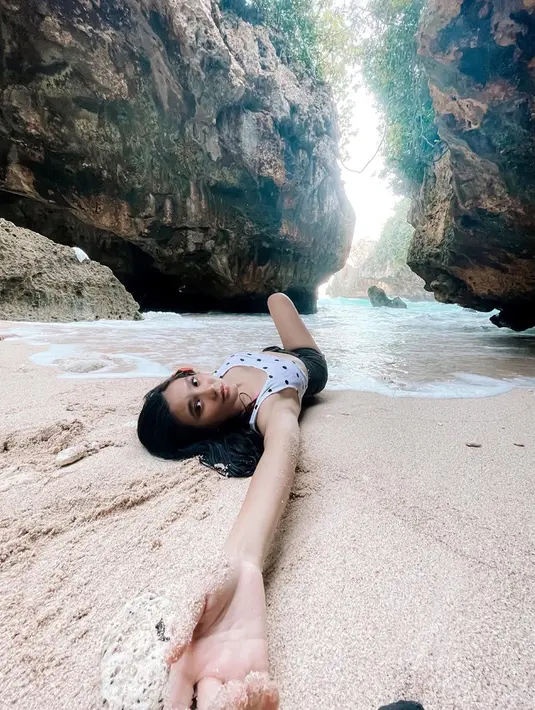 Main air dan pasir pantai menjadi salah satu aktivitas sederhana untuk menghilangkan sejenak penat setelah seharian beraktivitas. Tak hanya duduk di pantai menikmati pemandangan, tiduran di atas pasir pantai pun juga bisa dilakukan. Angle pengambilan foto yang totalitas membuat foto yang dihasilkan jadi makin keren dan menarik. (Liputan6.com/IG/@afifahifah23)
