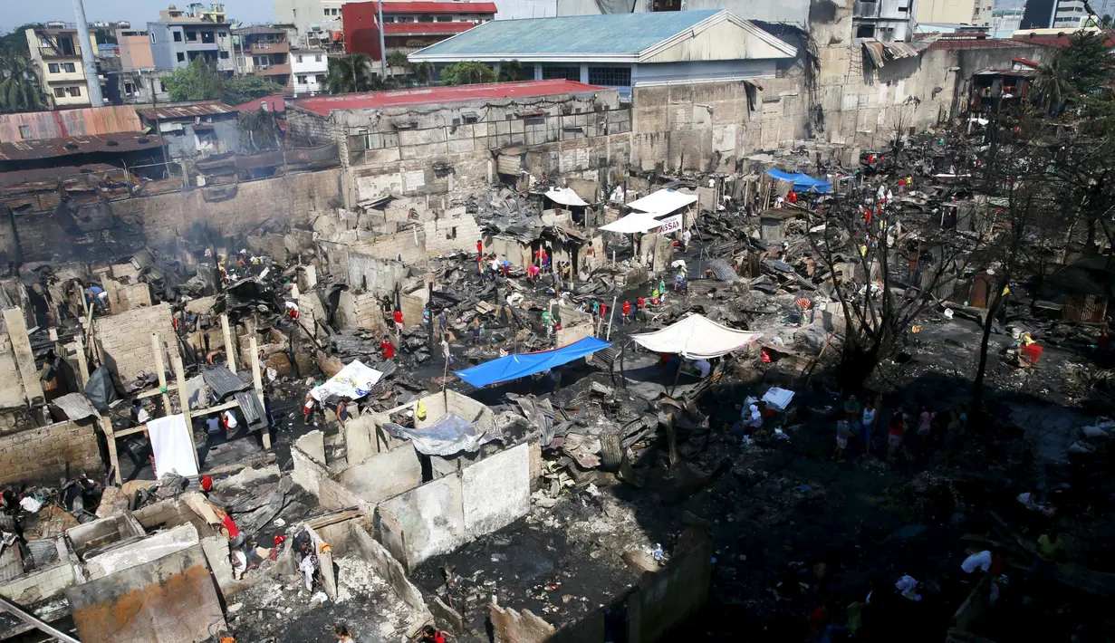 Puluhan warga Tampak mencari barang - barang yang bisa digunakan Pasca kebakaran yang terjadi di kota Quezon, Filipina, Jumat (23/10/2015). 325 keluarga kehilangan tempat tinggal dan sembilan orang lainnya mengalami luka-luka. (REUTERS/Romeo Ranoco)