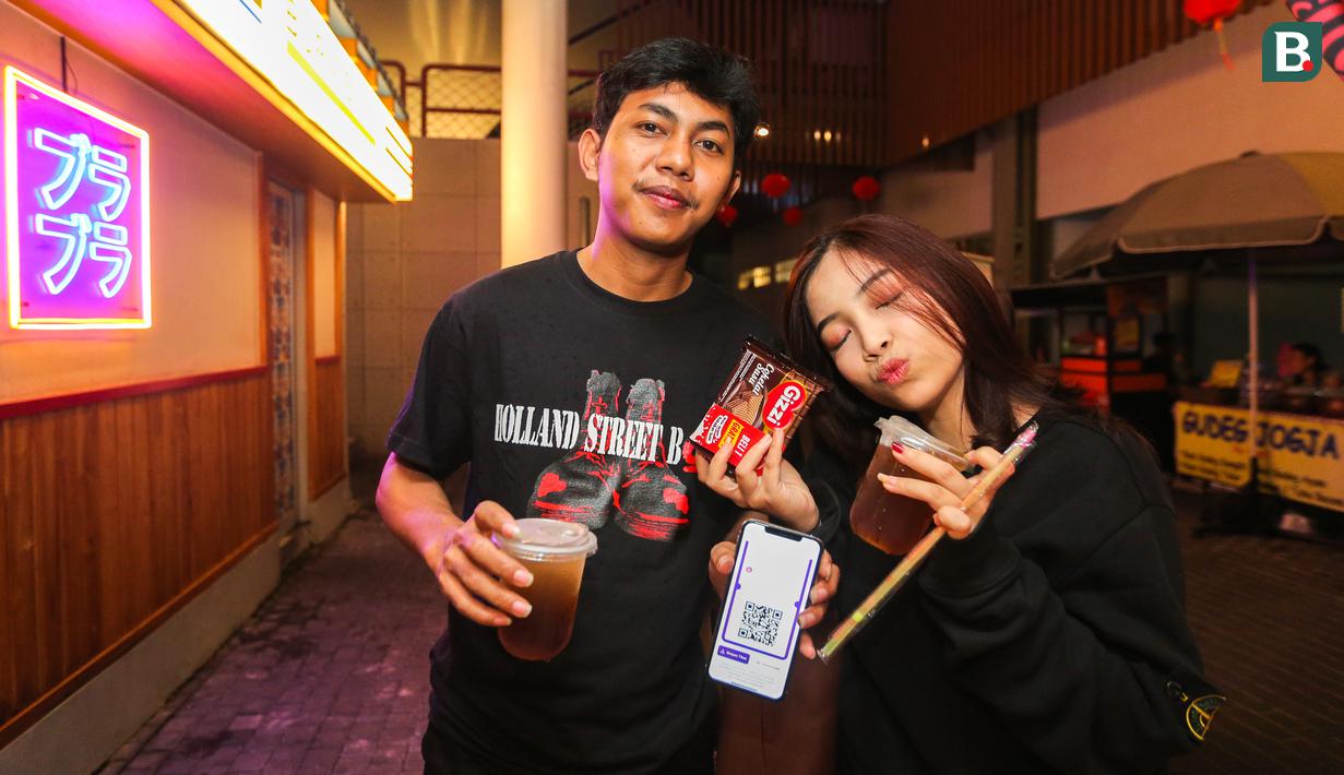 Sepasang pengunjung berpose setelah melakukan regristrasi saat Roaring Night Liga Inggris antara West Ham melawan Arsenal yang berlangsung di Triboon, Cilandak, Jakarta Selatan, Minggu (11/02/2024) malam WIB. (Bola.com/Bagaskara Lazuardi)