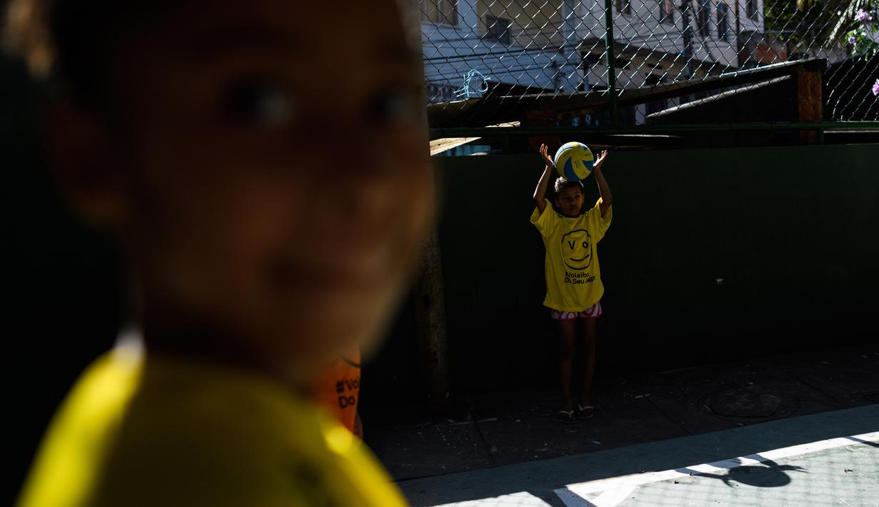 Anak-anak terlihat antusias mengikuti program Volleyball Development Training yang digagas oleh Federasi Bola Voli Internasional di Formiga favela, Rio de Janeiro, (2/8/2016). (AFP/Leon Neal)