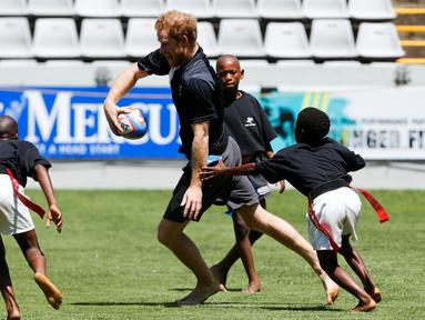 Pangeran Harry bermain rugby dengan anak-anak di Durban, Afrika Selatan, (1/12/2015). (Reuters/Rogan Ward)
