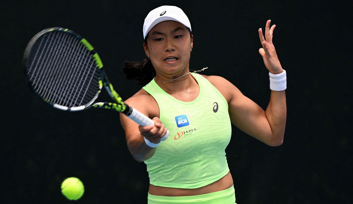 Namun, pada akhirnya, Karolina Pliskova memenangi set pertama dengan skor 6-4. Tampak dalam foto, petenis Indonesia, Janice Tjen memukul bola saat melawan Karolina Pliskova dari Republik Ceko selama pertandingan babak kedua tunggal putri turnamen tenis Australian Open 2026, di Melbourne, Kamis (22/1/2026). (Paul Crock/AFP)