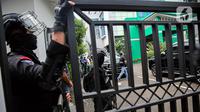 Nampak aparat kepolisian melakukan penjagaan ketat di Kantor MUI. Selain itu banyak juga anggota yang tengah memeriksa kondisi ruangan di depan pintu lobi MUI. (Liputan6.com/Faizal Fanani)