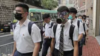 Para siswa sekolah mengenakan topeng dan helm berjalan di luar St. Paul's College selama protes di Hong Kong, Selasa (3/9/2019). Puluhan ribu siswa di Hong Kong mogok sekolah di hari pertama tahun ajaran baru. (AP Photo/Kin Cheung)