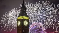 Kembang api menerangi langit di atas London Eye dan Elizabeth Tower, juga dikenal sebagai "Big Ben," di pusat kota London selama perayaan Tahun Baru pada Minggu (1/1/2022). Malam pergantian tahun identik dengan pesta kembang api. (Aaron Chown/PA via AP)