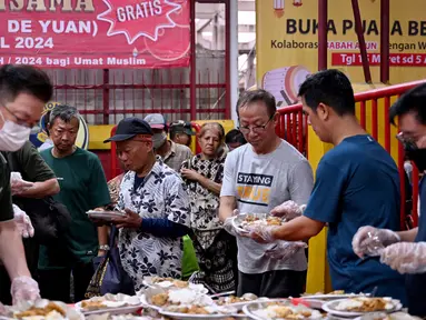 Para jemaat kelenteng Jin De Yuan membagikan makanan gratis kepada umat Muslim yang bersiap untuk berbuka puasa selama bulan suci Ramadan di Jakarta pada 18 Maret 2024. (Adek BERRY/AFP)