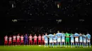 Pemain Manchester City (kanan) dan Red Star Belgrade berdiri saat mengheningkan cipta untuk mengenang para korban banjir Libya dan gempa Maroko sebelum pertandingan sepak bola Grup G Liga Champions antara Manchester City dan di Manchester, Inggris, Selasa (19/9/2023). Banjir Libya menewaskan lebih dari 11.000 orang dan 10.100 lainnya hilang, sementara gempa Maroko menewaskan setidaknya 2.900 orang. (AP Photo/Dave Thompson)