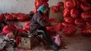 Seorang pekerja sedang membuat lampion merah menjelang perayaan Tahun Baru Imlek di provinsi Hebei, Tingkok (11/1). Jelang perayaan Imlek yang jatuh pada 15 Februari, warga setempat disibukan dengan pembuatan lampion. (AFP Photo/Fred Dufour)