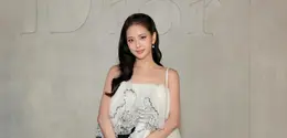 Jiso selalu tampil stunning, kali ini member Blackpink ini mengenakan atasan spagetti strap putih ruffle putih dengan bagian belakang menjuntai, dipadukan rok asymmetrical hitam polkadot. Dipadukan black pointed-toe pumps sambil membawa bucket bag hitam kecil dengan detail ornamen emas. [Dok. DIOR]
