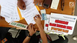Seorang warga menandatangani surat berita pelanggaran membuang sampah saat CFD di Jakarta, Minggu (28/1). Petugas Dari Suku Dinas Lingkungan Hidup DKI Jakarta melakukan OTT bagi para warga yang kedapatan membuang sampah. (Liputan6.com/Angga Yuniar)