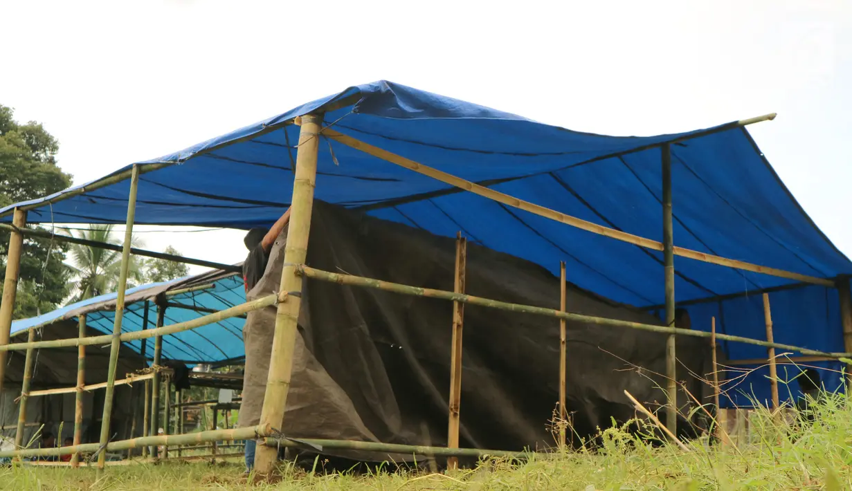 Warga memasang terpal untuk kamp pengungsian Gunung Agung di lahan milik dinas pertanian, Karangasem, Bali, Senin (27/11). Status Gunung Agung yang naik menjadi awas, membuat warga diminta mengungsi dari radius 8 hingga 10 km. (Liputan6.com/Andi Jatmiko)