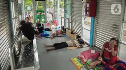 Korban banjir mengungsi di Halte Transjakarta Dispenda Samsat Barat, Jakarta Barat, Jumat (3/1/2020). Para korban terpaksa mengungsi ke halte tersebut akibat kurangnya posko pengungsian di sekitar lokasi terdampak banjir. (Liputan6.com/Faizal Fanani)