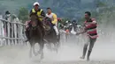 Sejumlah joki muda memacu kuda dalam lomba pacuan kuda tradisional di Takengon, Aceh, 10 Maret 2018. Kini kegiatan itu menjadi kalender tahunan pemerintah setempat untuk menjadikan daya tarik wisata di daerah tersebut. (AFP PHOTO/CHAIDEER MAHYUDDIN)