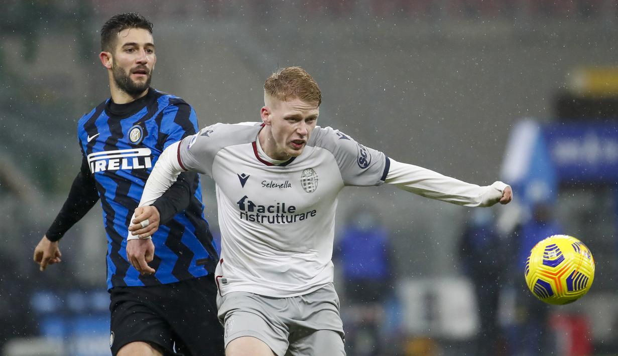Gelandang Inter Milan, Roberto Gagliardini (kiri), berebut bola dengan gelandang Bologna, Jerdy Schouten dalam laga lanjutan Liga Italia Serie A pekan ke-9 di San Siro Stadium, Sabtu (5/12/2020). Inter milan mengalahkan Bologna 3-1. (AP/Antonio Calanni)