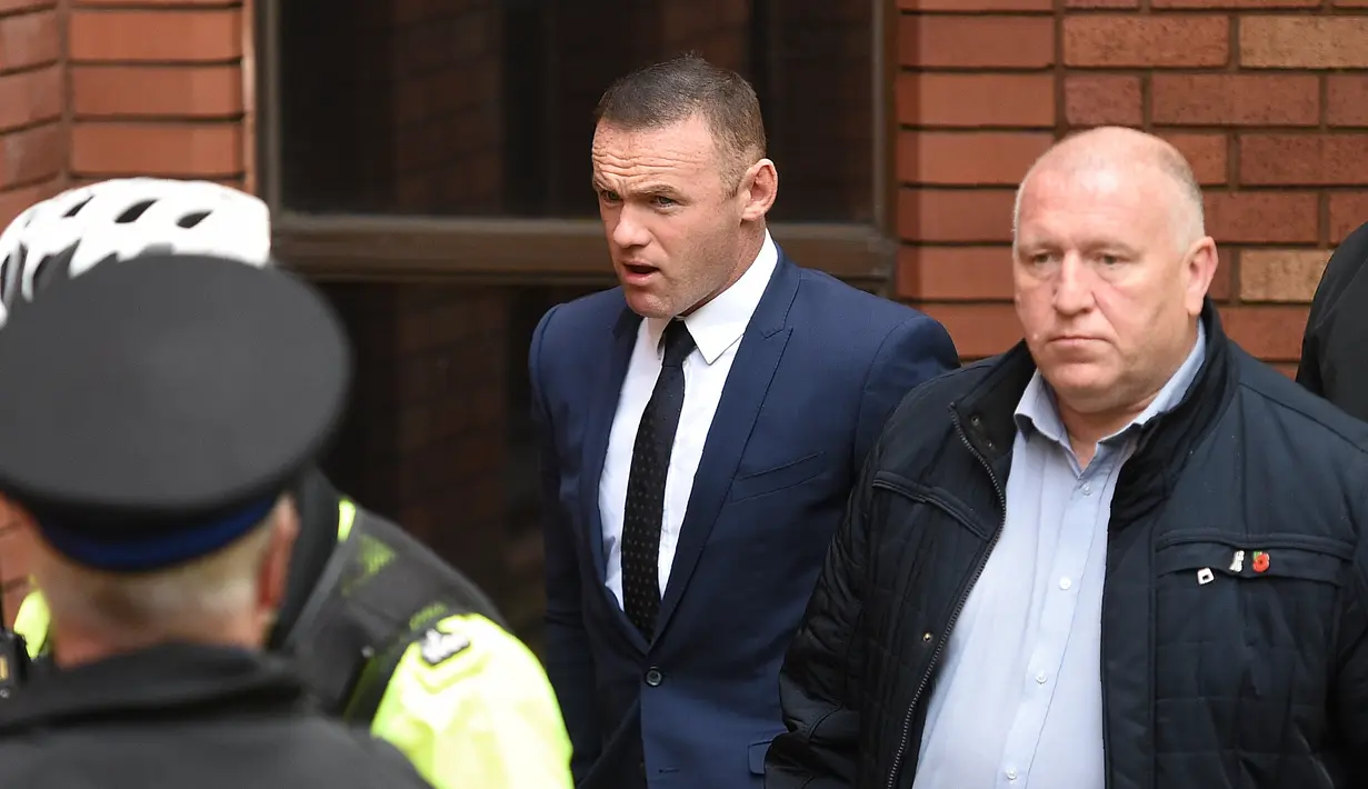 Ekspresi Wayne Rooney saat tiba di pengadilan Stockport Magpenrates di Stockport, Inggris (18/9). Sidang berlangsung sehari setelah Rooney tampil menghadapi mantan klubnya Manchester United di Premier League.  (AFP Photo/Oli Scarff)