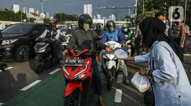 Aliansi Mahasiswa Lingkar Nusantara melakukan aksi dengan membagikan takjil di depan Gedung DPR/MPR, Jakarta, Rabu (6/4/2022). Dalam aksinya, mereka mendesak DPR untuk segera membentuk pansus terkait penambangan batu bara. (Liputan6.com/Johan Tallo)