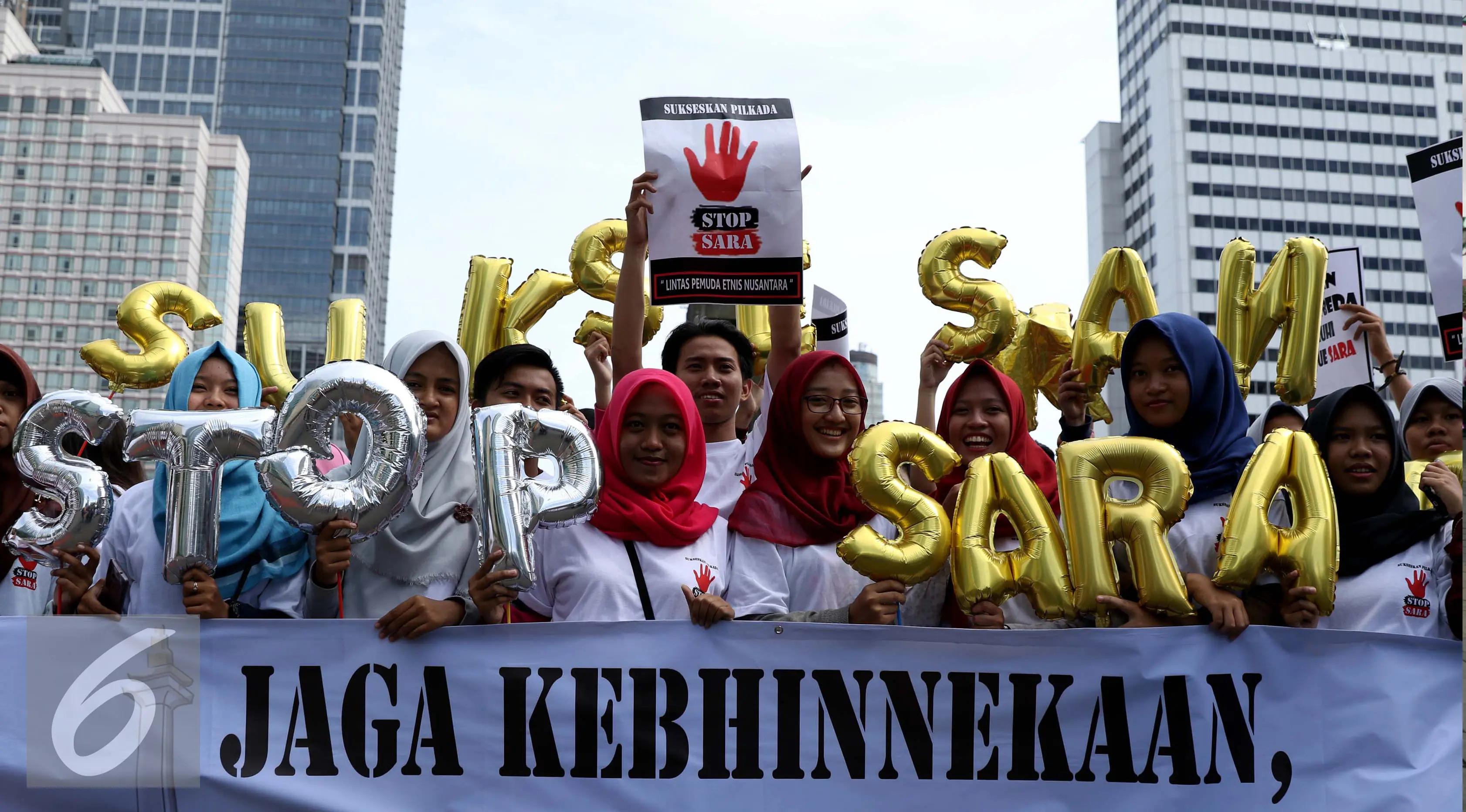 Massa yang tergabung dalam Lintas Pemuda Etnis Nusantara melakukan aksi kampanye di Bundaran HI, Jakarta, Minggu (10/9). Mereka mengajak warga agar tidak menggunakan isu SARA untuk menyukseskan Pilkada. (Liputan6.com/Gempur M Surya)