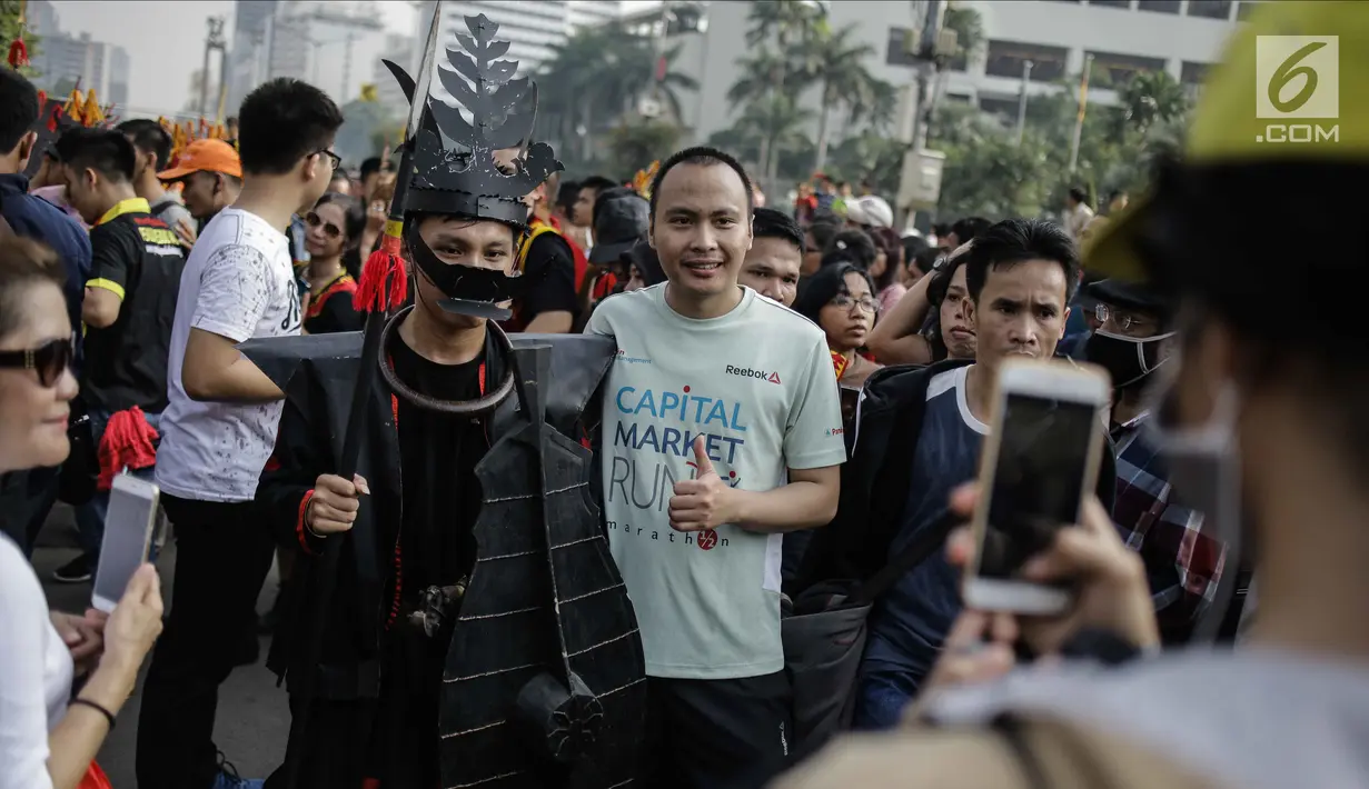 Warga berfoto dengan para peserta parade seni budaya Kepulauan Nias saat Car Free Day di Kawasan Jalan Sudirman, Jakarta, Minggu (4/3). (Liputan6.com/Faizal Fanani)