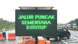 Papan informasi pengalihan arus lalu lintas usai terjadi longsor di kawasan Puncak Bogor, Jawa Barat (6/2). (Liputan6.com/Pool/Polres Bogor)