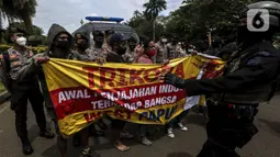 Polisi menjaga masyarakat Papua yang memperingati Operasi Trikora 19 Desember 1961 di Patung Kuda, Jakarta, Sabtu (19/12/2020). Massa juga menuntut penghentian rasisme dan politik rasial. (Liputan6.com/Johan Tallo)